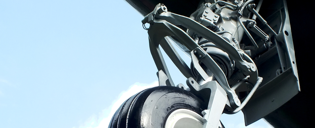 Aircraft landing gear assembly shown in close-up against clear sky