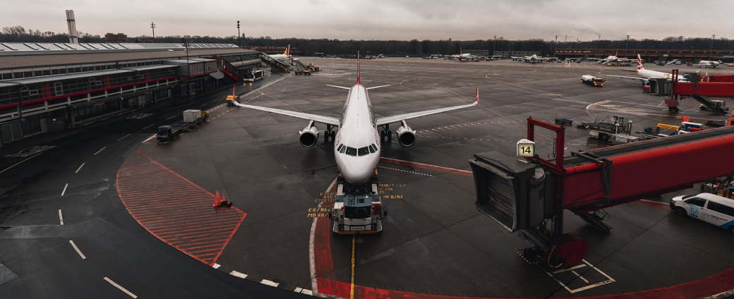 Commercial aircraft parked at airport gate during ground operations