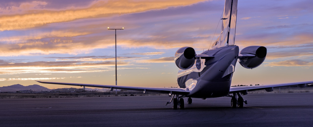 Business jet parked on the airport apron at sunset